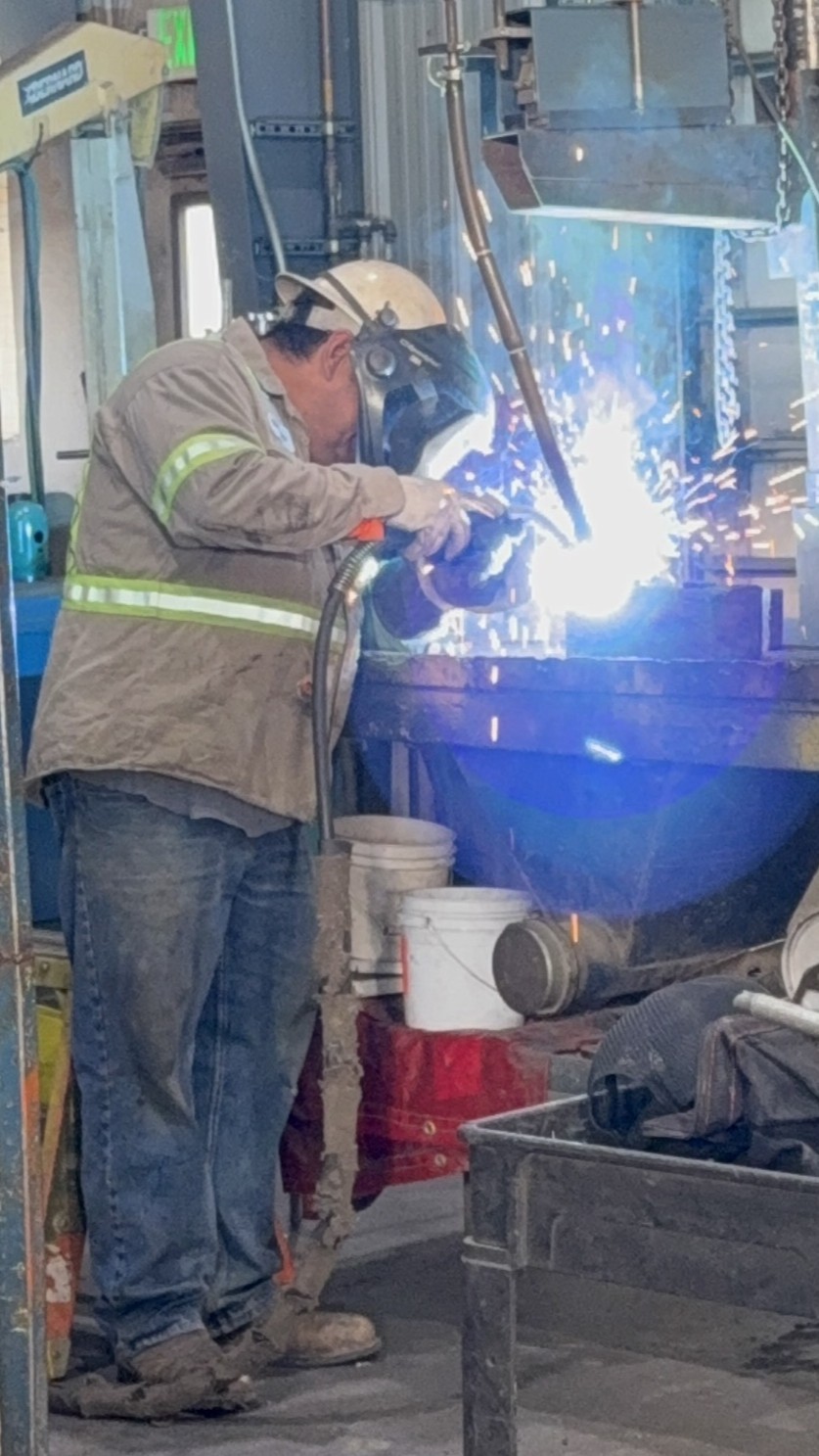 A CarWil technician is pictured in the CarWil Winnemucca headquarters, welding part of a pre-assembled module component for installation at Thacker Pass.
